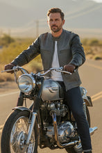 Rider in grey café racer leather jacket on classic motorcycle