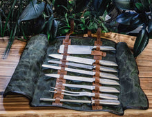 Handmade leather and canvas knife roll fully open displaying professional chef knives and tools