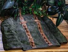 Back side of open waxed canvas knife roll showing full-length leather straps and handcrafted stitching