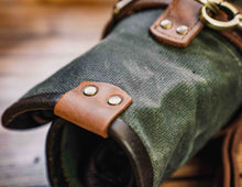 Detail of rolled waxed canvas knife bag with leather trim and rivets