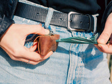 Leather Dog Poop Bag Holder in Use – Handcrafted brown leather pet waste bag dispenser attached to a belt, perfect for dog walks.