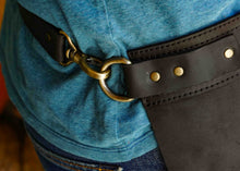 Leather half apron with a brass ring and black leather accents. This professional apron is perfect for baristas, bartenders, and chefs in need of a handmade, durable apron for daily use