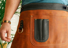 Detailed shot of a custom engraved leather apron, showcasing high-quality craftsmanship and brass details. Ideal for restaurant professionals and chefs looking for a durable, stylish work apron.