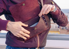 Back view of minimalist leather crossbody bag with adjustable belt and rivet details. A unique and practical accessory for women.