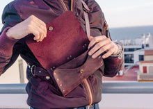 Woman modeling a wine-colored leather crossbody bag worn at the waist. Stylish, durable, and handmade for everyday use.