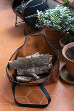 Image of a handcrafted leather log carrier showcasing durable construction and stylish craftsmanship, ideal for transporting firewood.
