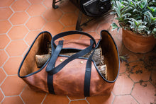 Image of a handcrafted leather log carrier designed for transporting firewood, displaying durable construction and stylish craftsmanship.