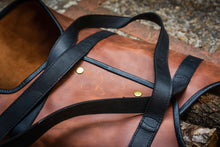 Description: This image shows a handcrafted leather log carrier designed for transporting firewood. It features durable construction and elegant craftsmanship, providing a stylish and practical solution for carrying logs.