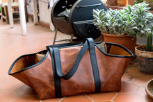 Handcrafted leather bag specifically designed for transporting firewood, displaying a combination of durability and stylish craftsmanship.