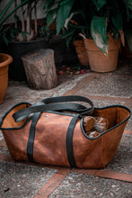 This image features a handmade leather log carrier, meticulously crafted for the purpose of transporting firewood. It offers a practical and stylish solution, ensuring ease of carrying logs with durability in mind.