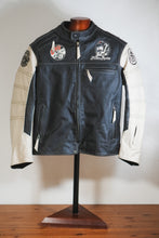 Black and white leather motorcycle jacket with café racer patches on mannequin, front view