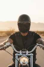 Man wearing black leather biker vest on motorcycle