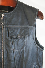 Chest pocket with embossed metal button and high-quality zipper on men’s leather motorcycle vest.