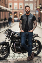 Man wearing black leather biker vest with motorcycle — handmade men’s motorcycle club vest street style.