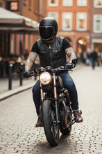 Rider wearing black cowhide leather biker vest — handmade men’s motorcycle gear in action.