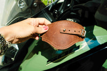 Hand holding leather shift boot protector – close-up of craftsmanship and stitching – ideal biker gift