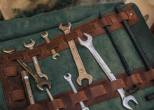 Handcrafted green and brown leather motorcycle tool roll opened with wrenches