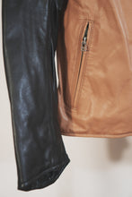 Detail view of black leather sleeve with zipper on tan café racer jacket