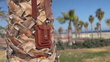 brown and black leather vertical bags with wide crossbody strap