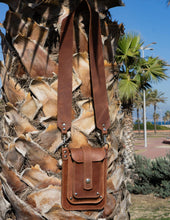 Brown leather phone bag with wide crossbody strap and multi pocket