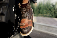 Close-up of brown leather motorcycle shifter protector on boot