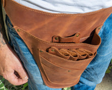 Brown leather barber tool belt with brass rivets