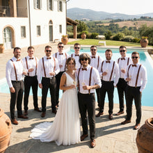 Group of people in formal attire by a pool with a scenic background