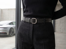 Black croc leather belt photographed at the waist