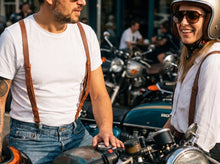 Man and woman wearing brown leather suspenders with jeans at a motorcycle cafe meet
