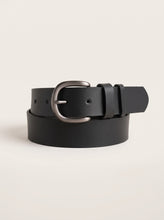 A black leather belt with a silver-tone metal buckle, neatly coiled on a light beige background.