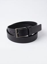 A black leather belt with a silver-tone metal buckle, neatly coiled on a light gray background.