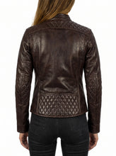 A woman viewed from the back wearing a dark brown leather jacket with quilted panel detailing on the shoulders, sleeves, and lower back, paired with black jeans against a plain white background.