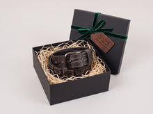 Men's genuine leather belt in a luxury black gift box with decorative shredded paper, dark metal buckle, green velvet ribbon, and gift tag – premium gift set for men.