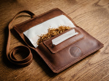 Handmade brown leather tobacco pouch with long strap, tobacco compartment, rolling paper holder, and stitched leather construction.