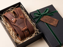 A personalized brown leather suspenders set presented in an open black gift box with gift message