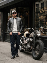 Black and grey leather motorcycle jacket for men worn on a cafe racer bike