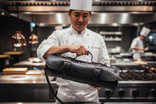 Professional chef holding handmade black leather knife bag
