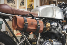Brown leather motorcycle tool bag mounted on a vintage café racer, featuring dual buckle straps, carry handle, and durable storage for motorcycle tools, road trips, and everyday riding essentials. Garage storage