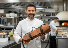 Chef holding handmade brown leather knife roll bag with black straps by Fashion Racing