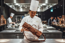 Chef holding brown leather knife roll bag