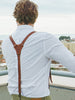 brown leather suspenders with a white shirt, showcasing the fine leather texture