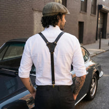 A man wearing black leather suspenders with a Y-back design