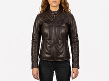 A woman wearing a dark brown leather motorcycle jacket with quilted shoulder panels and a front zipper, paired with black jeans, against a plain white background.