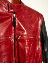 Close-up of a red leather jacket with black accents on a plain background