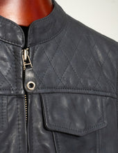 Close-up of a dark gray quilted vest with a zipper on a mannequin.