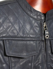 Close-up of a dark gray leather vest with quilted pattern and zipper detail.