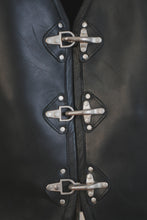 Close-up of clasp fasteners on black leather vest