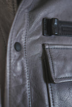 Chest pocket of gray leather trucker jacket