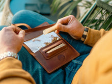 Vintage leather tobacco pouch with wrap closure. Handmade travel-friendly rolling accessory for smokers. Compact and durable design, ideal for storing rolling papers, filters, and tobacco on the go.