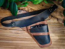 A black and brown leather belt tool bag with a wide strap and a front pouch